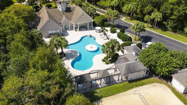 Une propriété résidentielle dotée d’une piscine, d’un patio couvert et d’une pelouse bien entretenue.