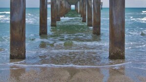 Un molo che si estende nel mare, sorretto da numerose colonne in cemento.