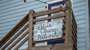 A wooden staircase leading to a blue door with a sign that reads "Blue Ohana Hideout".