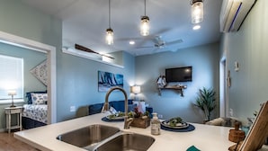 A modern kitchen with a large island, double sink, and pendant lighting.