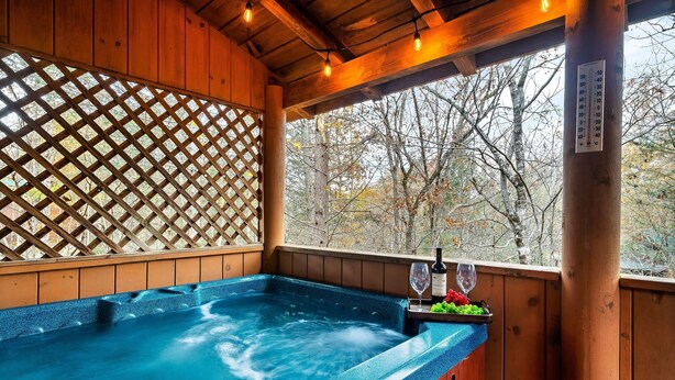 A hot tub with a wooden deck and a view of trees. - *Starlink Wifi* Peaceful Log Cabin Near National Park & Dollywood (Sevierville)