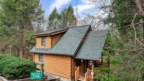 A log cabin with a steeply pitched roof, a front porch, and a small window. - *Starlink Wifi* Peaceful Log Cabin Near National Park & Dollywood (Sevierville)