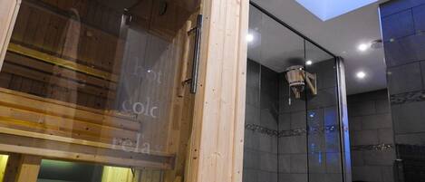 Un interior moderno con un banco de madera, un separador de vidrio y una pared de piedra.