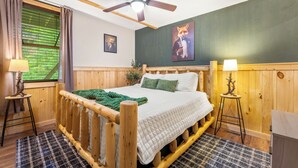 A wooden-framed bed with a quilted white duvet, a ceiling fan, a green wall, and a framed painting of a fox. - Smoky/ Mountain views/ King bed/ bunk bed/en suite bath/Hot tub/Sauna/Pet/value (Sevierville)