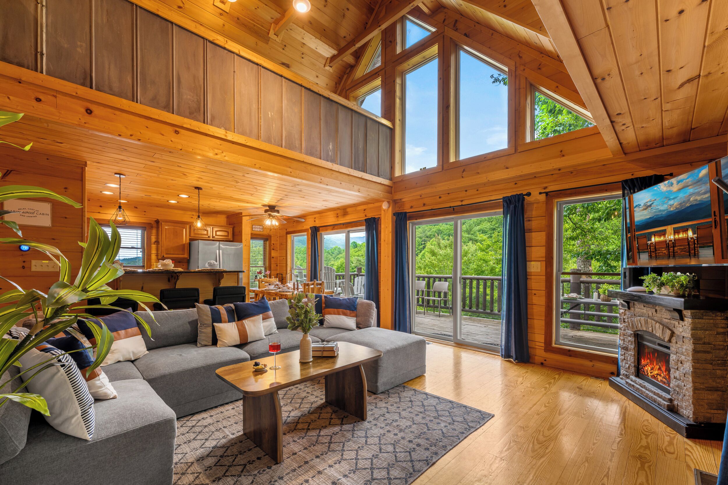 A spacious cabin interior with a large living area, a dining space, and a fireplace.