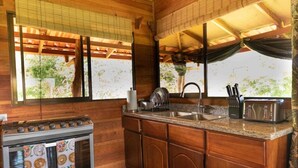 Une cuisine compacte dotée de meubles en bois, d’un évier en acier inoxydable, d’un four encastré et d’un grille-pain.