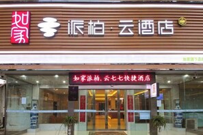 A hotel entrance with a sign indicating it is part of the "如家" hotel chain.