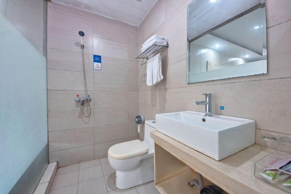 A modern bathroom with a toilet, sink, and shower.