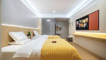A modern hotel room with a bed, bedside table, and a wall-mounted TV.