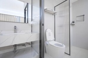 A modern bathroom with a white sink, a toilet, and a glass shower enclosure. - Hongfangzi Hotel (Phoenix Lake Park) (Yuanmou)