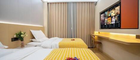A hotel room with two beds, a large window with curtains, a flat-screen TV on the wall, and a small table with a chair.