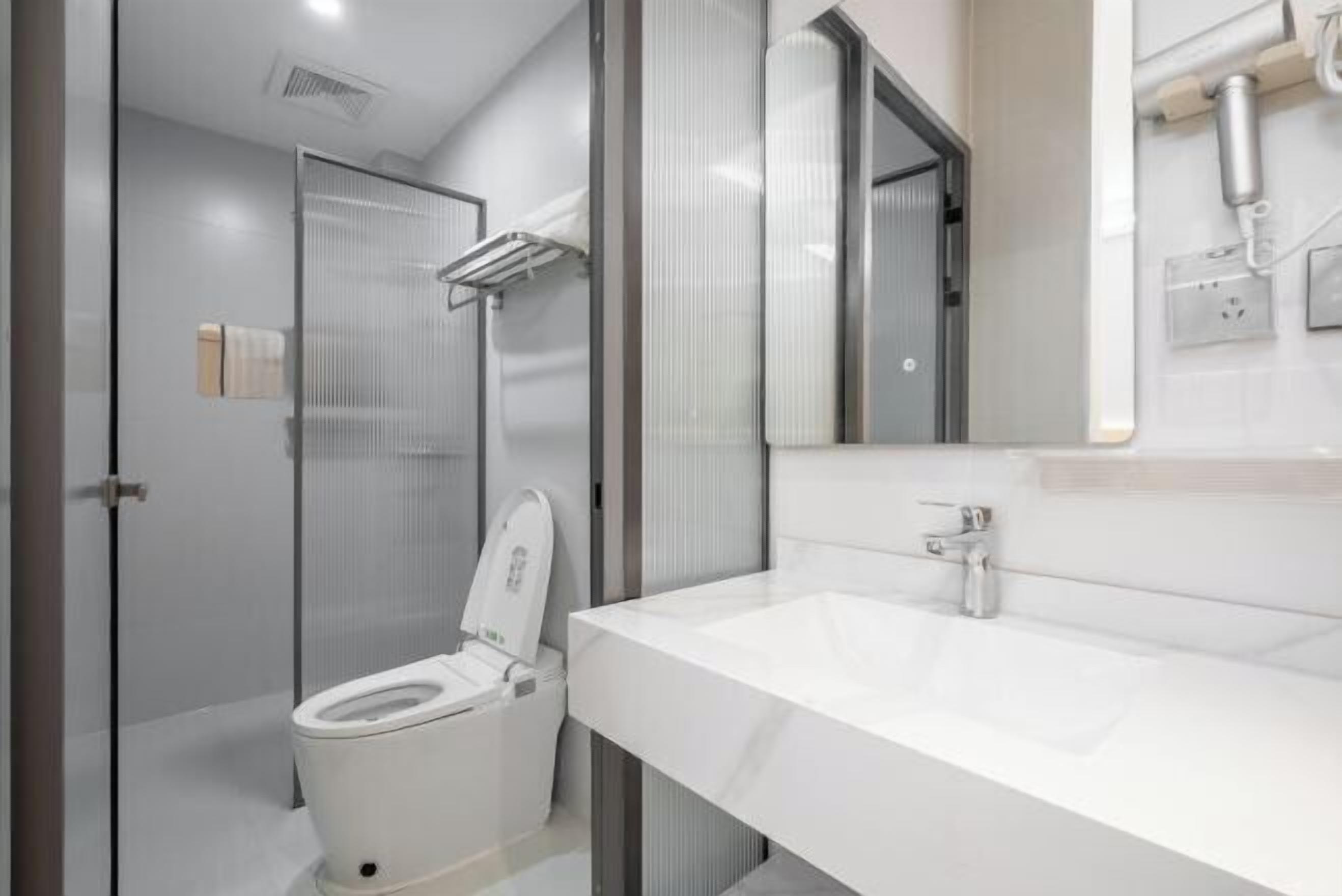 Un baño moderno con inodoro, ducha y lavamanos.