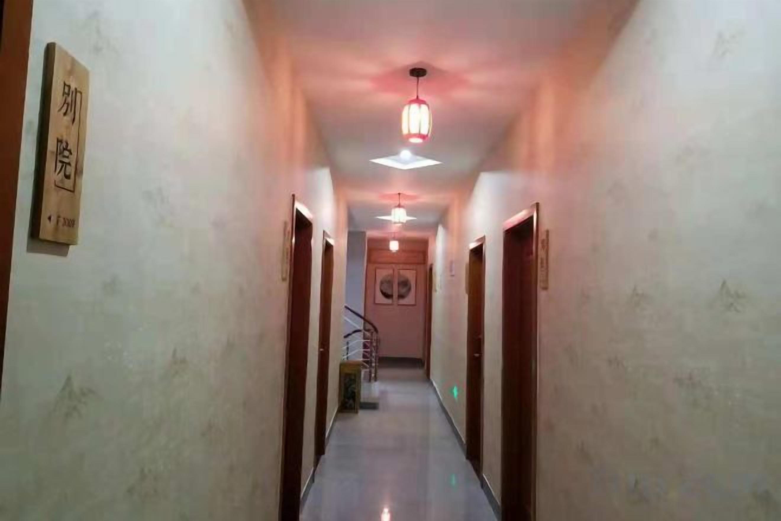 A hallway with a ceiling light fixture, a staircase, and a door on the right.