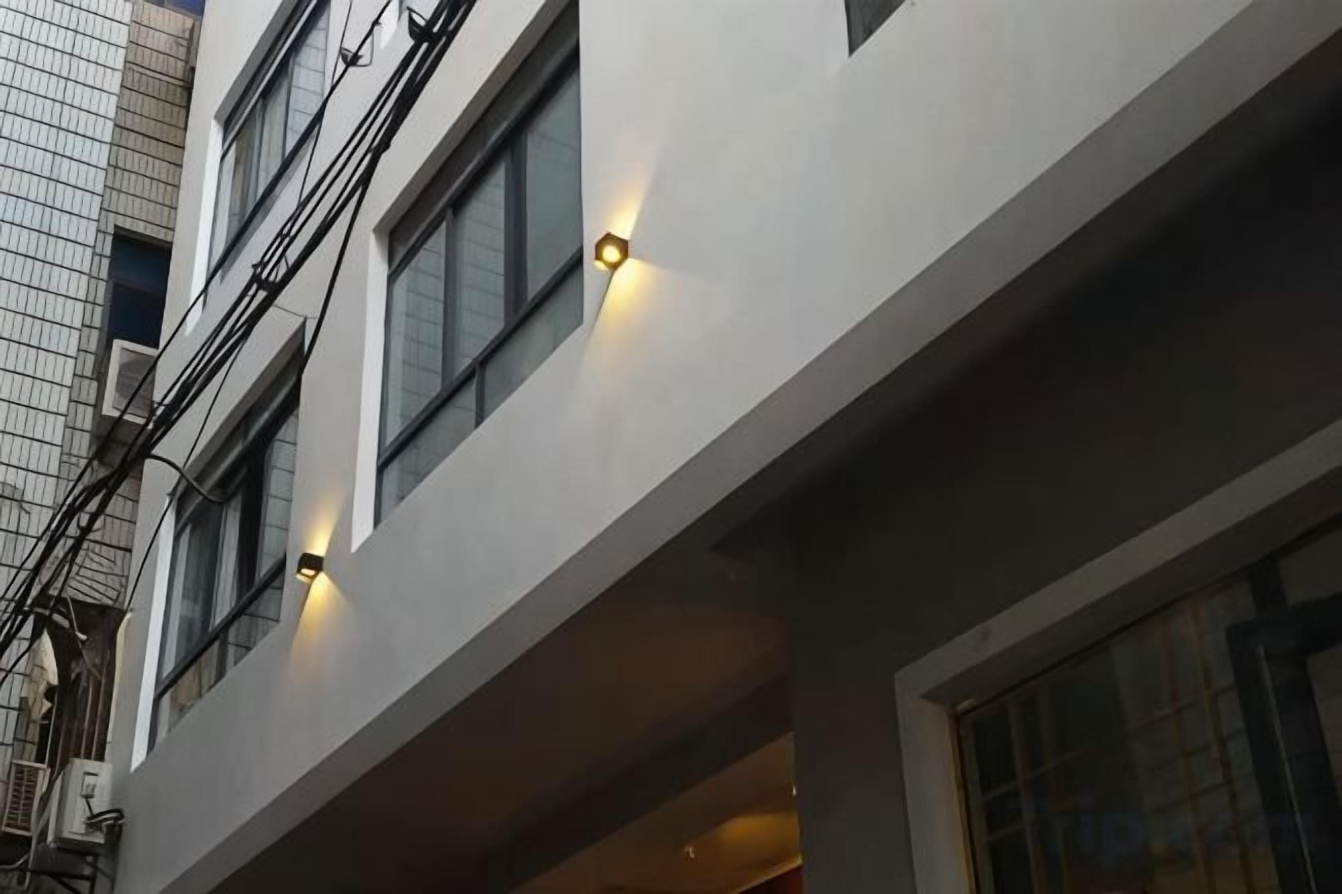 Une façade d’immeuble avec de nombreuses fenêtres, dont certaines sont dotées d’un éclairage extérieur.
