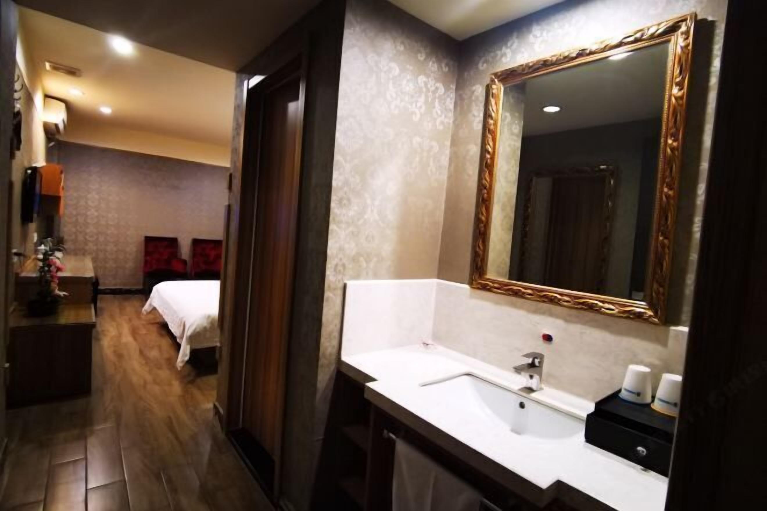 Un baño de hotel con un espejo grande, un lavamanos y un inodoro.