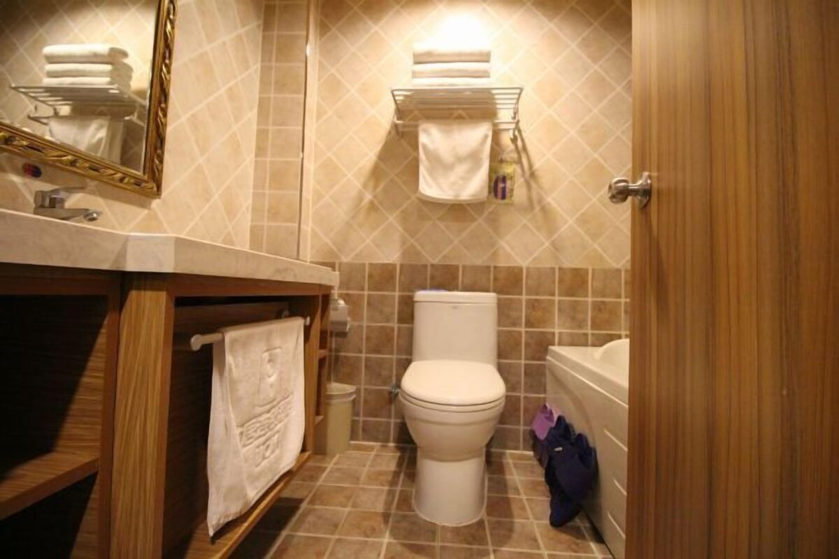A bathroom with a toilet, sink, and towel rack.