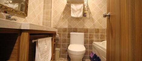 Ein Badezimmer mit Toilette, Waschbecken und Handtuchhalter.
