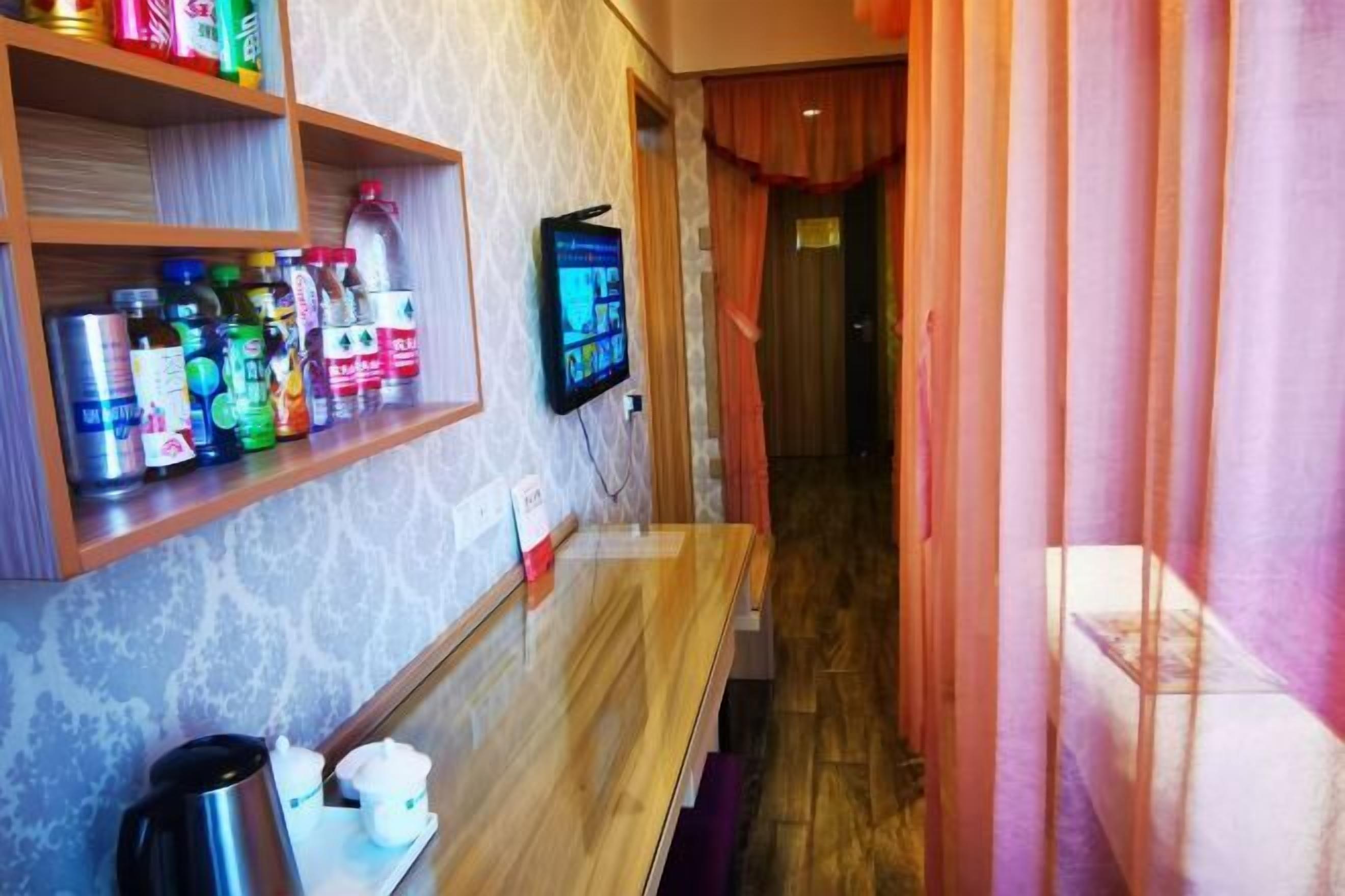 A hotel room with a wooden bench, a coffee station, and shelves with various items.