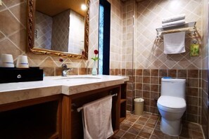 A bathroom with a marble sink, a mirror, a toilet, and a towel rack.