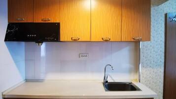 A kitchen with wooden cabinets, a white countertop, and a stainless steel sink.