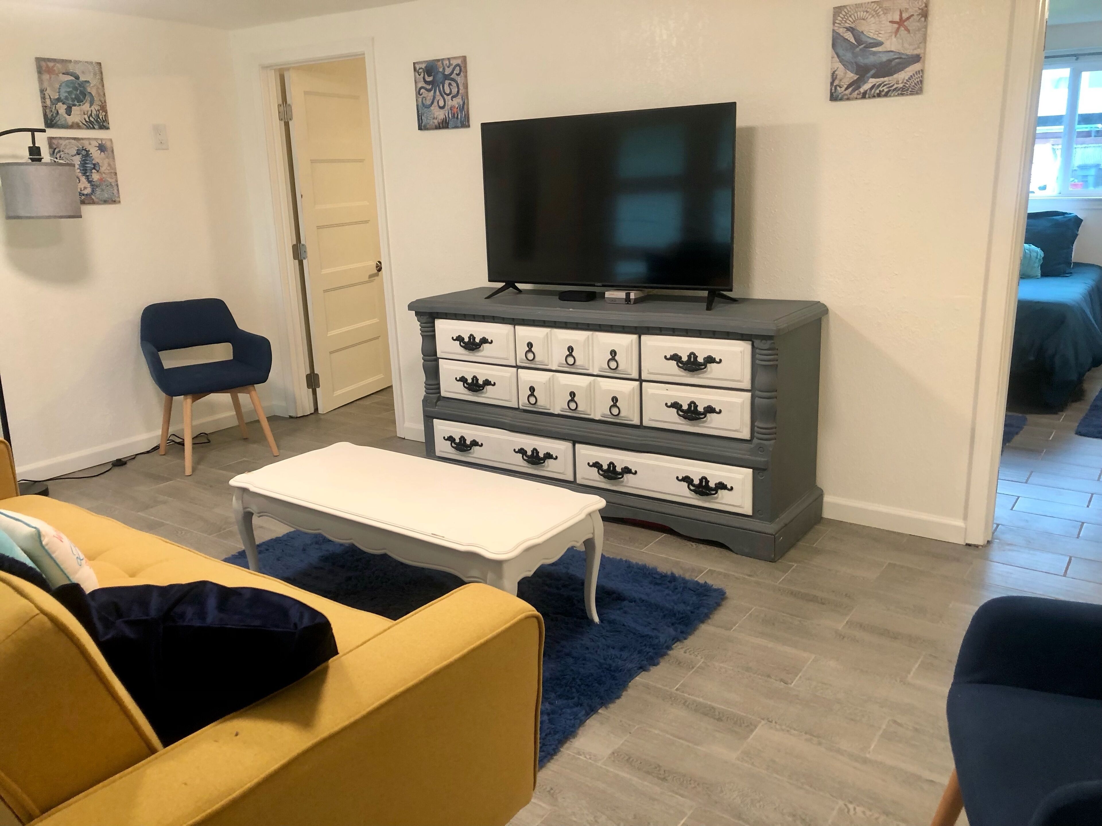A living room with a television on a dresser, a sofa, and a chair.