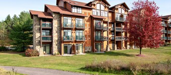 Golf-front modern condo with fireplace, balcony, & golf course views