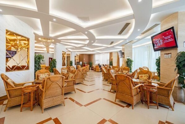 A spacious lobby with wicker furniture, a large TV screen, and a modern ceiling design. - Wan Li Duo Hotel (Mingshu) (Chengdu)