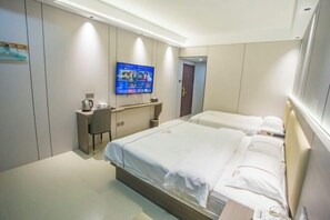 A hotel room with a bed, a desk, and a TV mounted on the wall. - Kaiyuanbinguan (Wuhu)