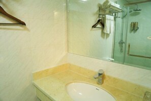 A bathroom with a sink, mirror, and shower. - Kaiyuanbinguan (Wuhu)