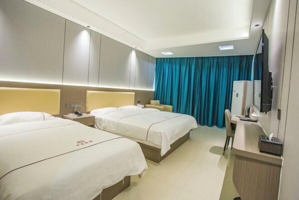 A hotel room with two beds, a desk with a computer, a TV, and a minibar. - Kaiyuanbinguan (Wuhu)