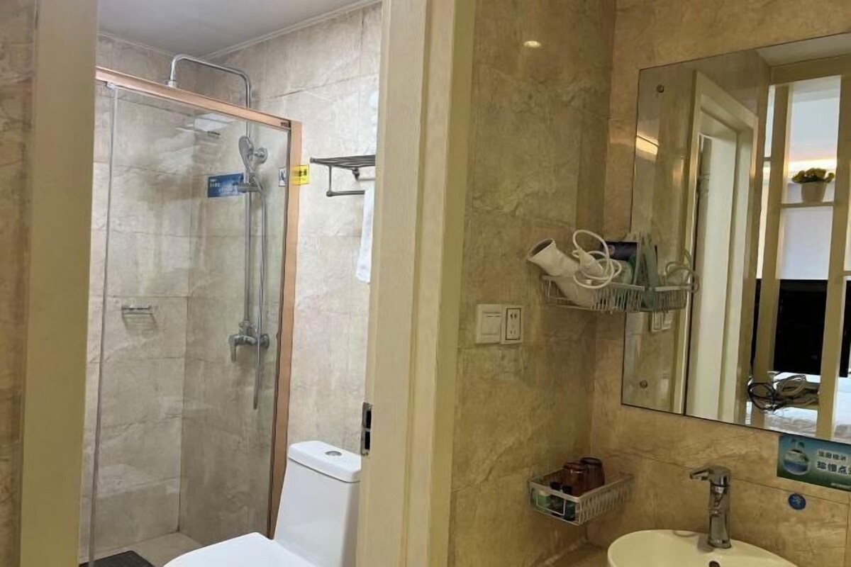 A bathroom with a glass-enclosed shower, a sink with a mirror, and a towel rack.