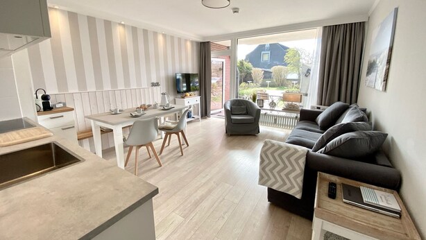 A modern apartment with a kitchen, dining area, and living room.