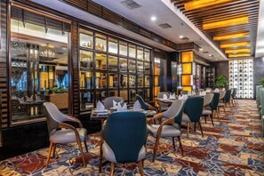A restaurant with tables and chairs, a patterned carpet, and a modern interior design. - Forum Hotel Hunan (Changsha)