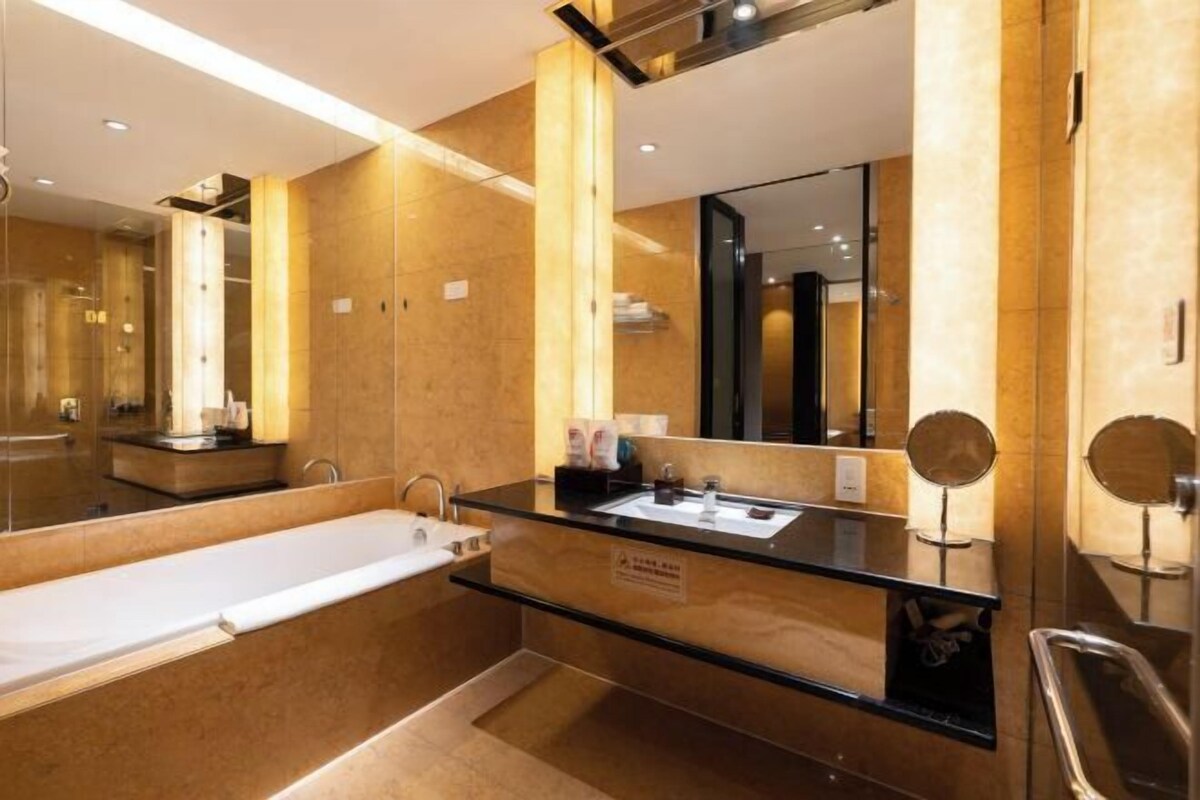 Une salle de bain moderne avec une baignoire, un lavabo et un grand miroir.