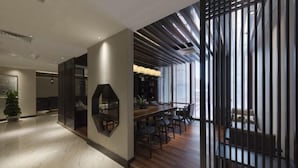 Een modern interieur met een houten eethoek, een groot raam en een decoratief wandpaneel.
