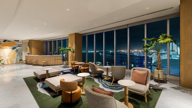 A modern lobby with a reception desk, seating area, and large windows offering a city view. - Hilton Garden Inn Yokohama Minatomirai (Yokohama)