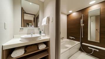 A modern bathroom with a sink, mirror, towel rack, and a bathtub with a shower head.