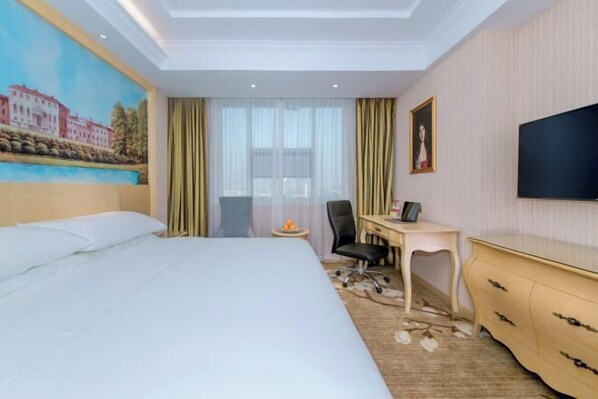 A hotel room with a large bed, a desk, a chair, a TV, and a painting on the wall.