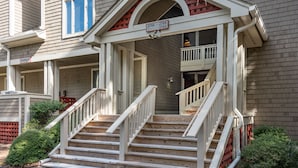 A two-story house with a front porch, a staircase, and a mailbox.