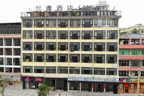 A multi-story building with a flat facade, multiple windows, and a ground-level entrance. - lanyi Hotel (Guiding)
