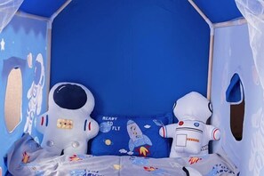 A blue-themed room with a bed, pillows, and a toy rocket. - lanyi Hotel (Guiding)