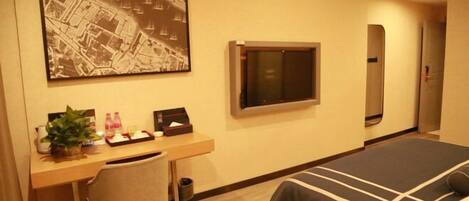 Habitación de hotel con cama, escritorio, silla y un mapa grande en la pared.