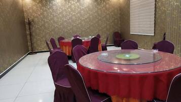 A conference room with round tables, purple chairs, and a glass table.