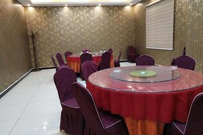 A conference room with round tables, purple chairs, and a glass table. - Guyuecun Hotel (Yongde)