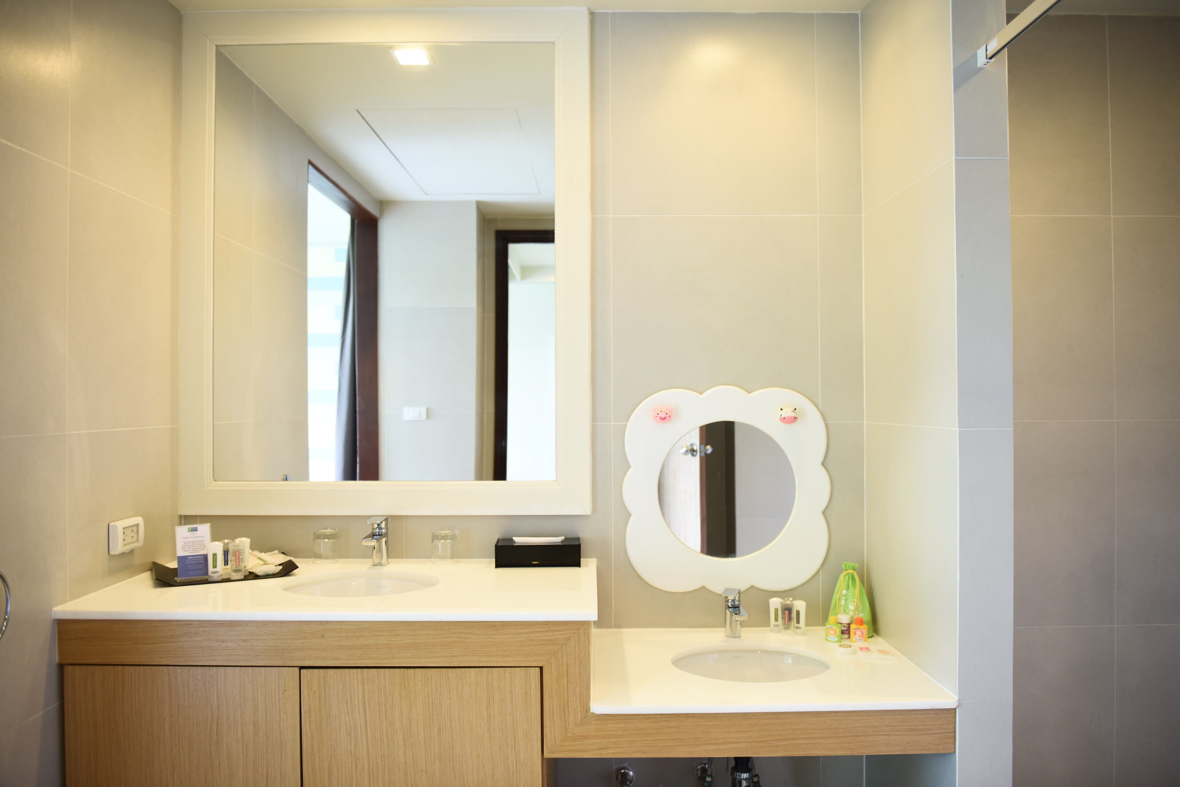 Un baño moderno con dos lavamanos, un espejo grande y una zona de ducha.