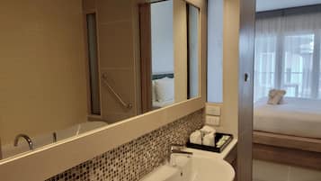 A modern bathroom with a large mirror, a sink, and a shower.