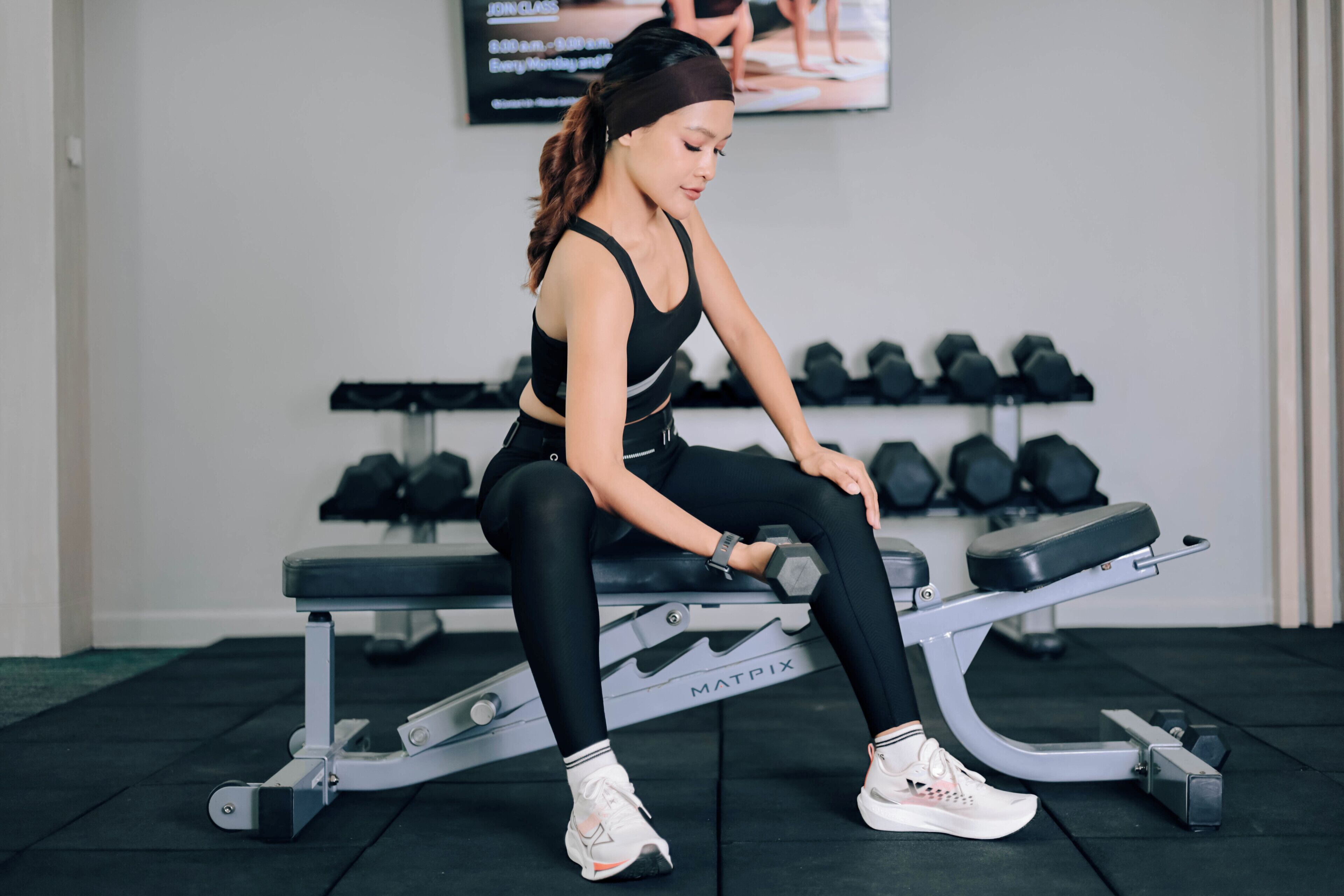 A gym with a bench, dumbbells, and a mat.