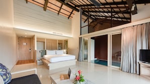 A modern hotel room with a large bed, a desk with a laptop, a marble coffee table with flowers, and a TV. - Holiday Ao Nang Beach Resort Krabi (Krabi)