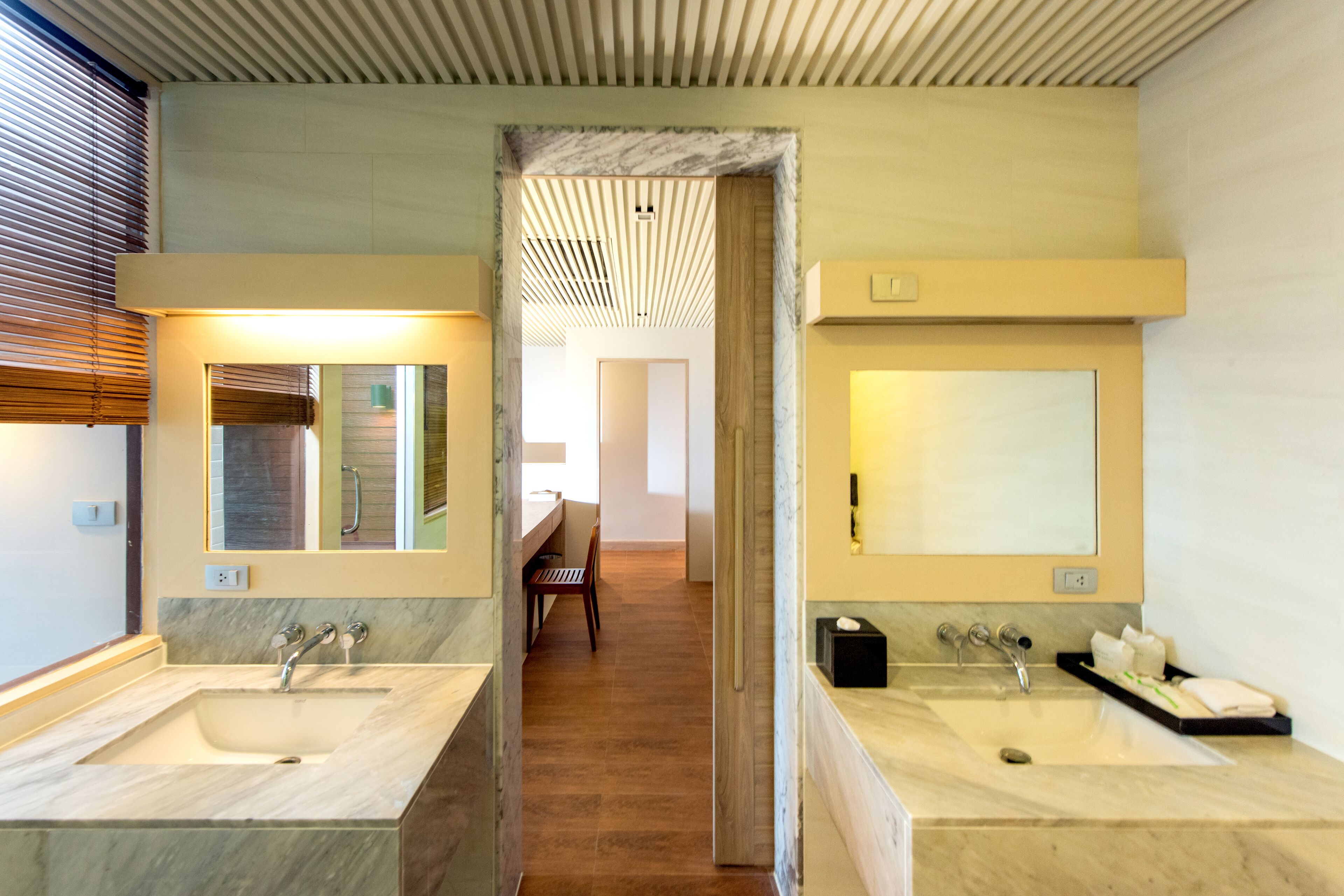 A modern bathroom with two sinks, a mirror, and a shower area.