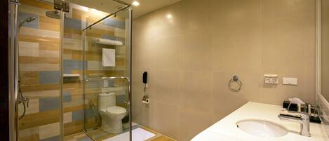 A modern bathroom with a glass-enclosed shower, a white sink, and a toilet.
